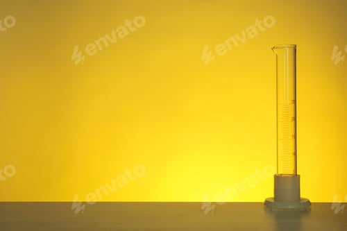 Preview: Empty graduated cylinder on table against color background. Chemistry laboratory glassware