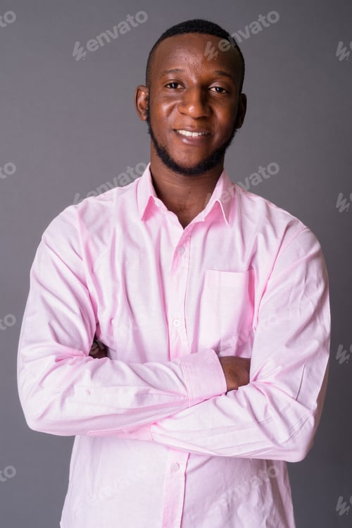 Preview: Young handsome African man with short hair against gray backgrou