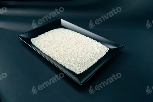 Preview: top shot white round rice lies on black and blue background on a black long flat plate Japanese
