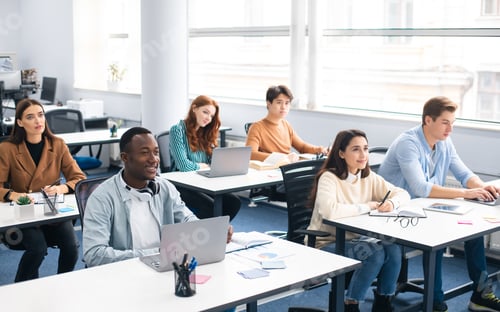 Preview: Group of international people listening to teacher at classroom