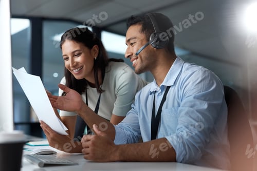 Preview: Shot of a young man and woman reading a document while working in a call centre
