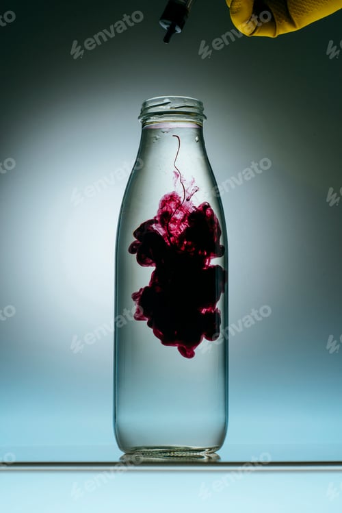 Preview: cropped view of person pouring purple paint into bottle with water