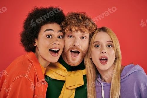 Preview: polyamorous concept, portrait of young man and multicultural women on coral background, studio shot,