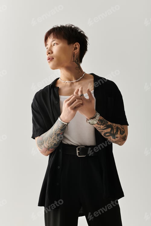 Preview: Stylish young Asian man confidently poses in a modern studio setting with artistic flair