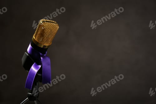Preview: Microphone with purple awareness ribbon on dark background, space for text