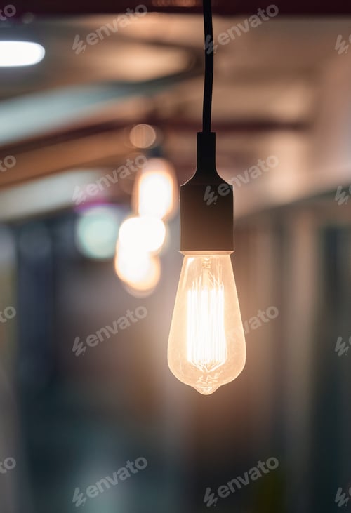 Preview: Shot of a lightbulb hanging from the ceiling in an empty office in the evening