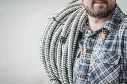 Vista previa: Trabajador de construcción eléctrica con un tubo de conducción en el hombro