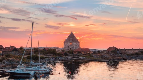 Preview: Mesmerizing shot of Christiansoe island, Bornholm Denmark with boats at sunset
