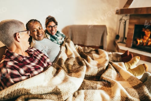 Preview: Multiracial friends having fun in front of cozy fireplace at home