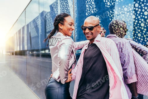 Preview: Cheerful mixed race couple embracing each other outdoors