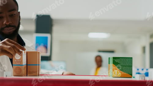Preview: Pharmacy worker organizing products on shelves
