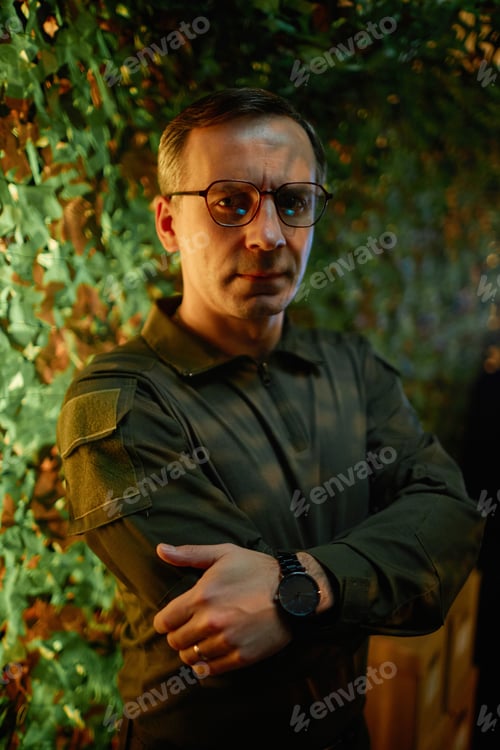 Preview: Confident mature male security officer in eyeglasses and uniform