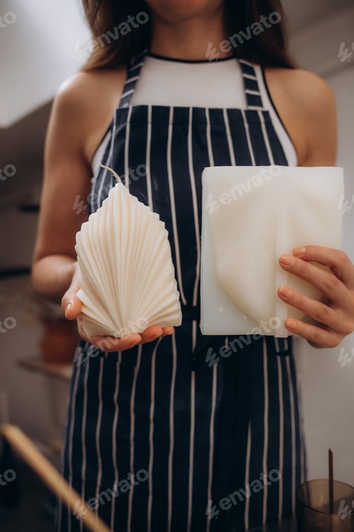 Preview: a woman in an apron holds a candle made by herself