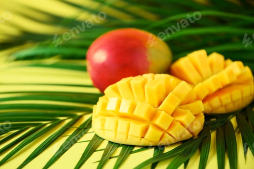 Preview: Exotic mango fruit over tropical green palm leaves on yellow background. Copy space. Pop art design