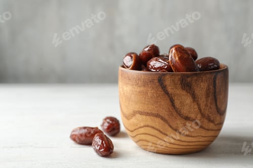 Preview: Bowl with sweet dates on table, space for text. Dried fruit as healthy snack