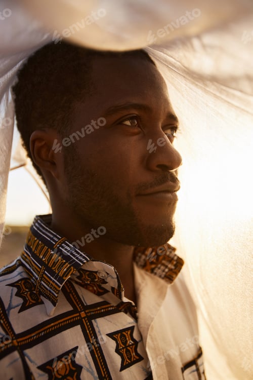 Preview: Smiling African American Man Looking Away Outdoors Covered with Veil