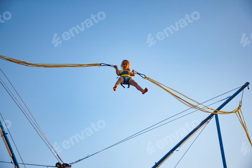 Preview: Little girl flies on elastic bands and jumps on a trampoline