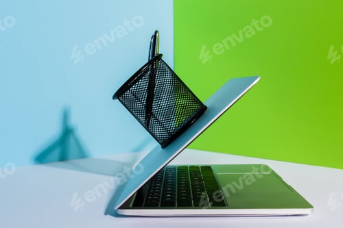 Preview: Pen in Holder on Modern Laptop on Blue, White And Green Background