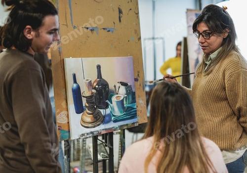 Preview: Mature latin teacher working with students inside art class room at school