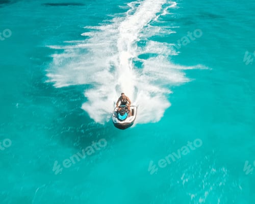 Preview: View of a person riding a jet ski on clear turquoise water