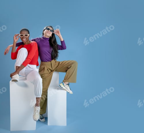 Preview: Two women pose on blue background with copy space banner