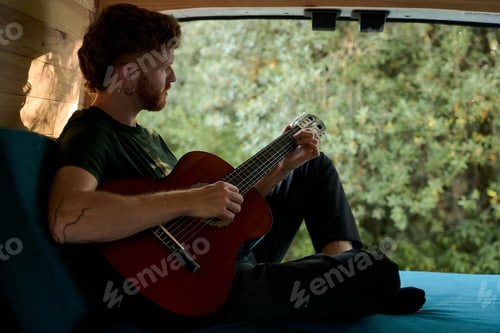 Preview: Musician playing acoustic guitar in camper van
