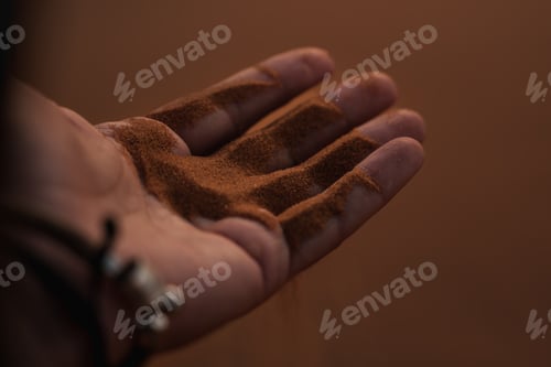 Preview: Tourist holding red sand of erg chebbi dunes in merzouga, sahara desert, morocco