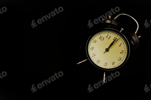 Preview: Black alarm clock with black background.