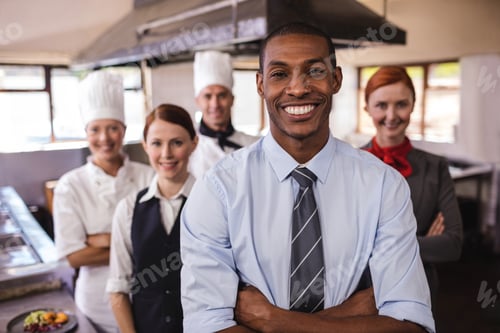 Preview: Group of hotel staffs standing with arms crossed in kitchen