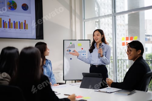Preview: Asian businesswoman presenting financial data to office team
