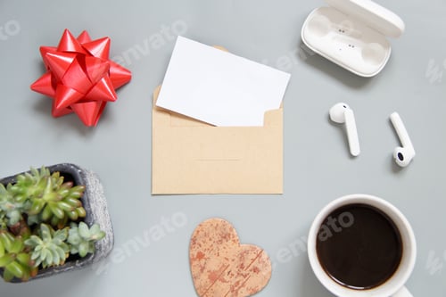 Preview: Black card with envelope top view on grey table.