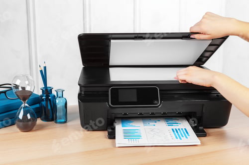 Preview: Unrecognizable young businesswoman making copies on the photocopy machine at the office