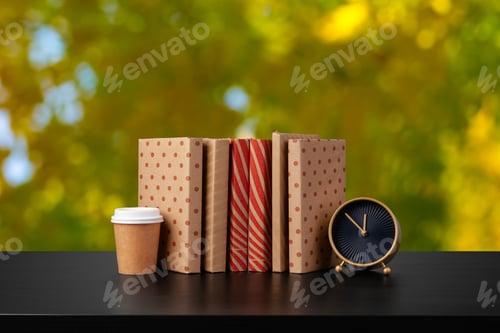 Preview: Stack of books on wooden table against blurred background