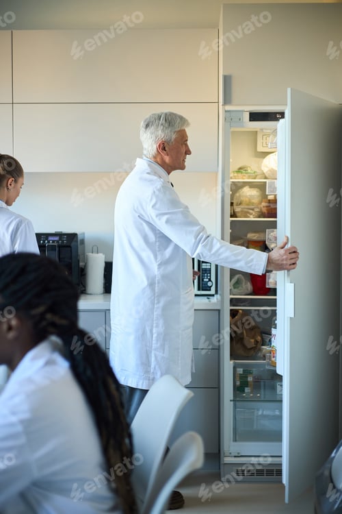 Preview: Older Scientist Opening Refrigerator in Laboratory Setting