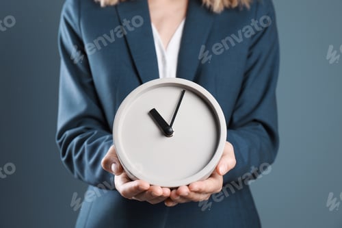 Preview: Young businesswoman holding clock on color background. Time management