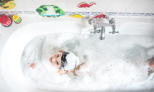 Preview: Boy sitting in bath, bubbles on head, smiling, overhead view