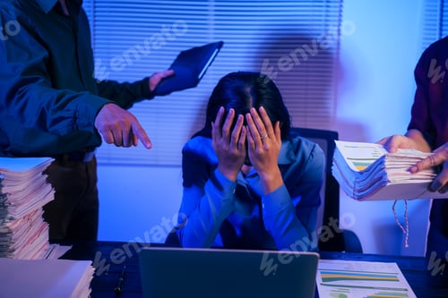 Preview: Two men bring a large workload to a woman at her desk in the office. She feels stressed pressured