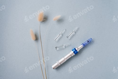Preview: Fractional Mesotherapy Device and Serum Ampoules for Skin on a Blue Background