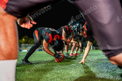 Preview: American football players preparing for a game at night