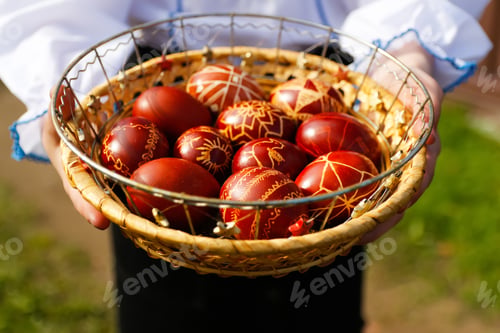 Preview: a Ukrainian girl holding and showcasing beautifully decorated Easter eggs, known as pysanka, in a tr