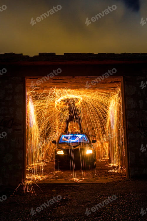 Preview: Person with burning round on car in garage in darkness