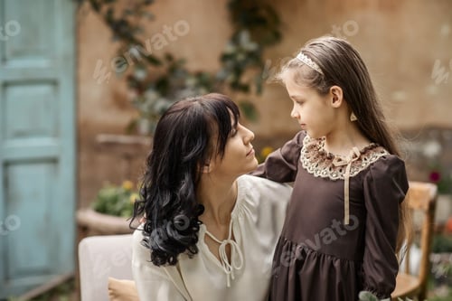 Preview: happy mom and daughter in the courtyard of a country house