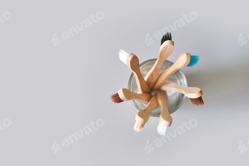 Preview: Set of ecology toothbrush on grey background. Different color at glass. Diversity
