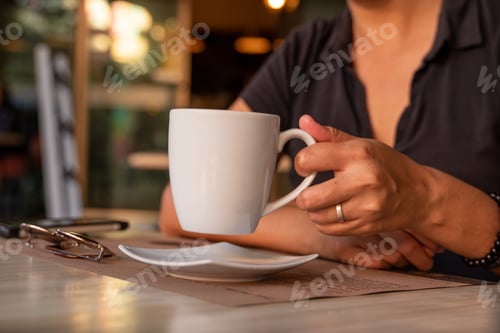 Preview: Adult Holding White Mug Indoors During the Daytime