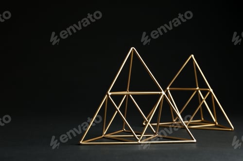 Preview: Shiny decorative gold pyramids on black background. Space for text