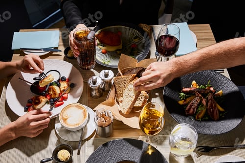 Preview: cropped view of people eating delicious food in restaurant