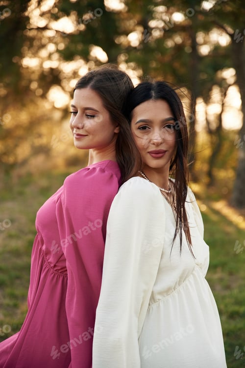 Preview: Standing and posing. Lovely lesbian couple are together outdoors in nature