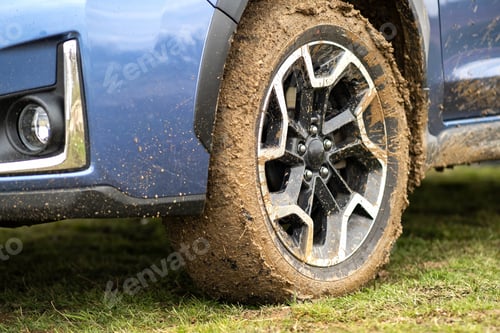 Preview: Close up of dirty car wheel with rubber tire covered with yellow mud