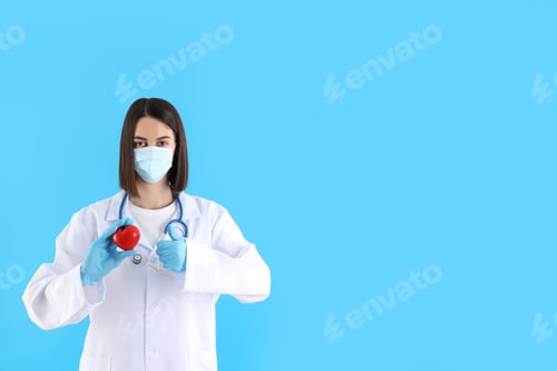 Preview: Young Woman Doctor Holding Red Heart on Blue
