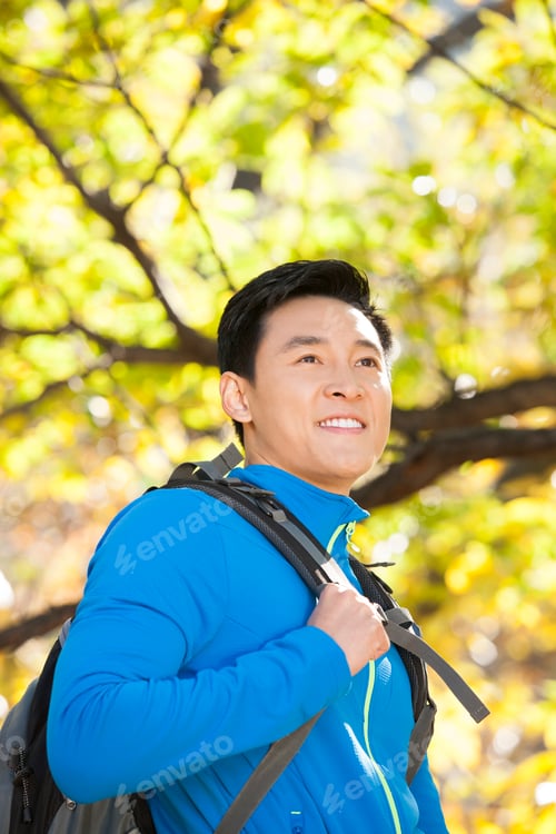 Preview: Happy male backpacker on a hike